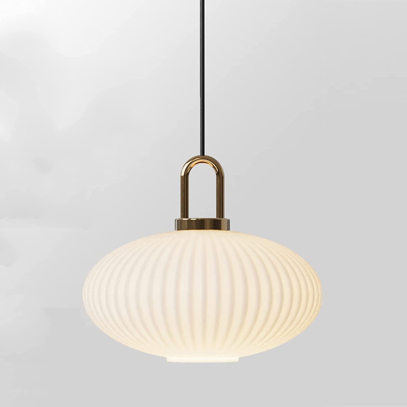 Wide flattened white ribbed glass shade glowing below a gold-tone loop and black cord