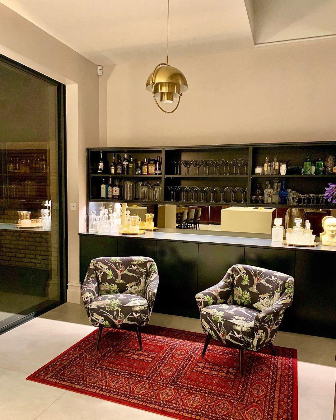 Gold-toned ring pendant above a lounge area in front of a bar.