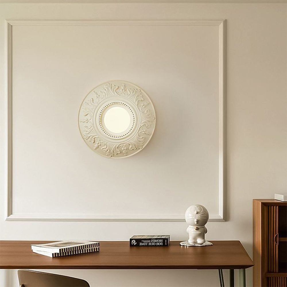 Cream medallion globe light above a wooden desk with books and a white character sculpture
