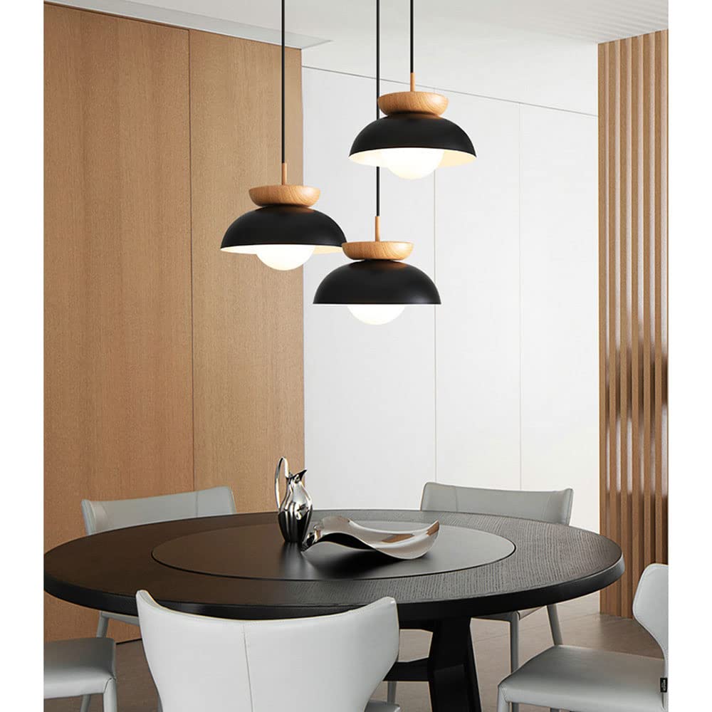 Three Black dome pendants with wood accents at different drops above a dark round table
