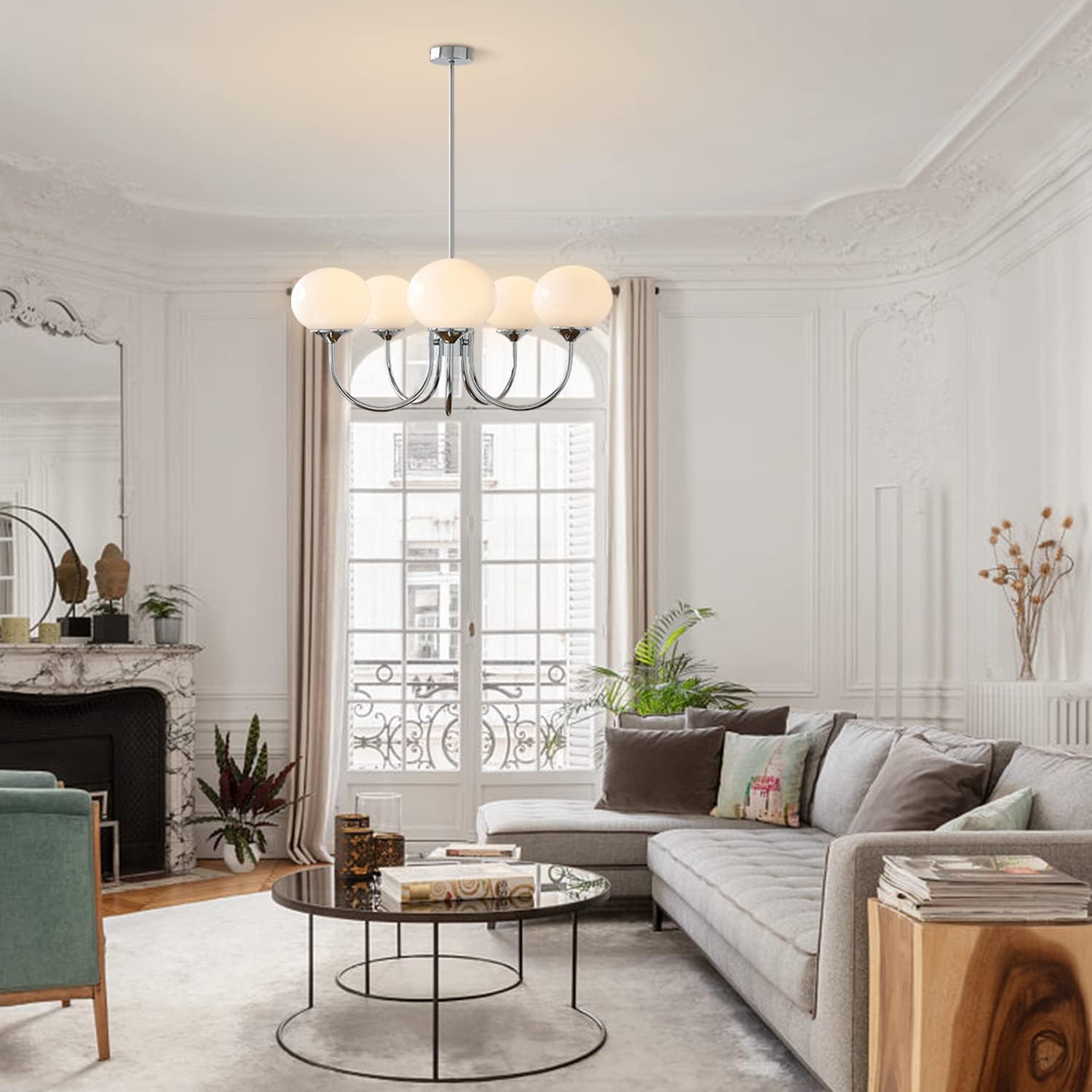 Five pale illuminated globes on chrome-tone arms above a living-room coffee table and sofa