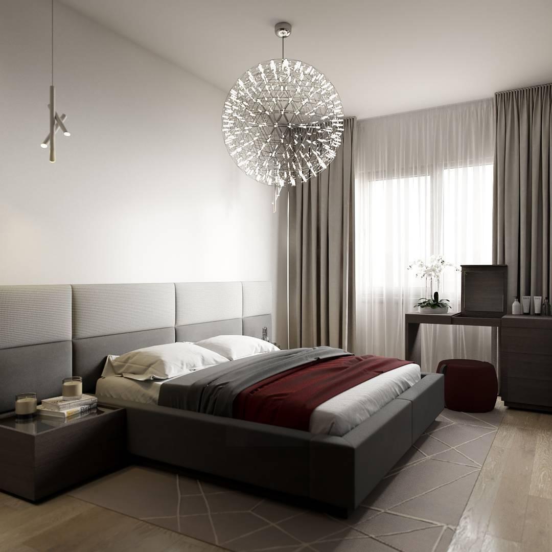 Single lattice globe over a grey bed with a burgundy throw and an orchid on a dresser