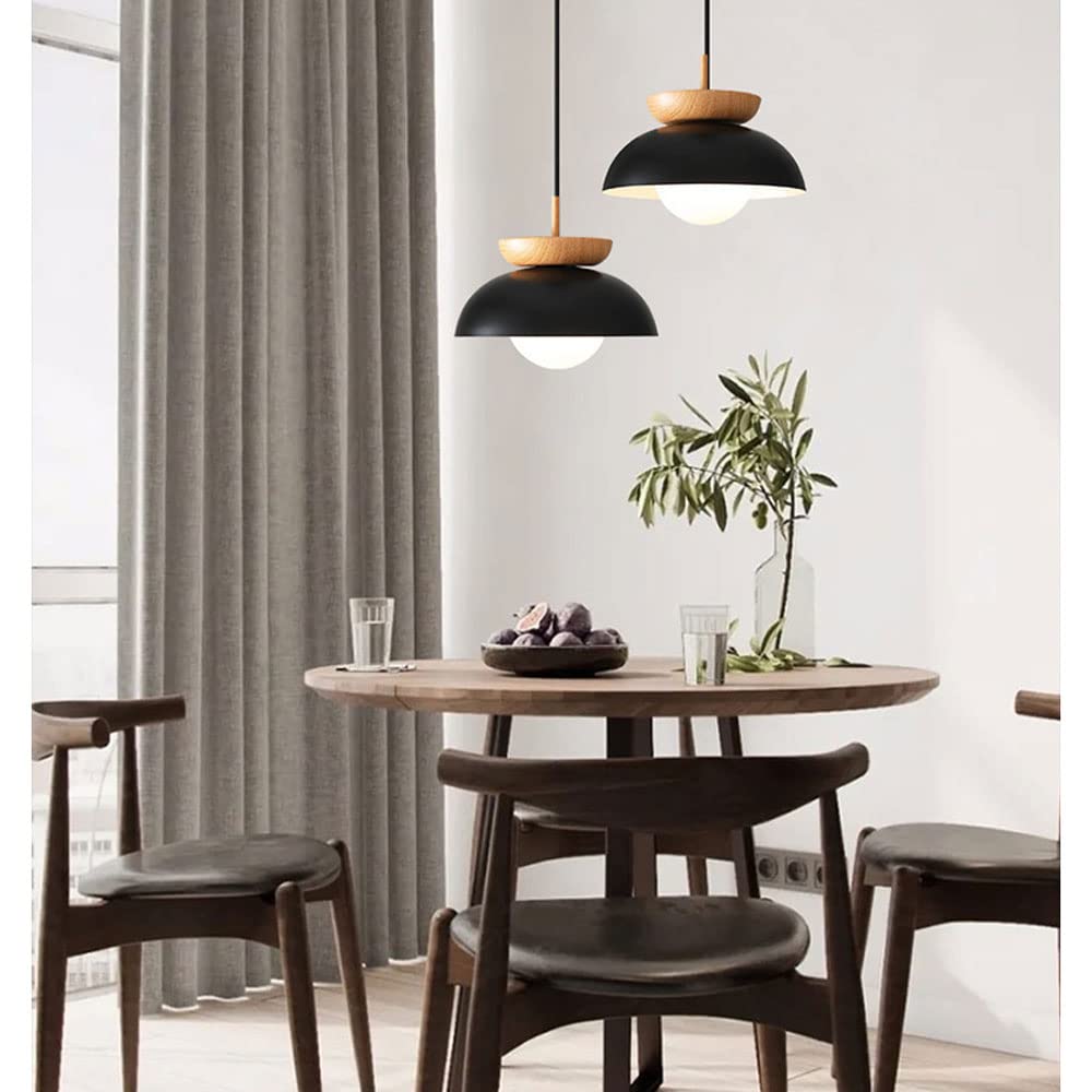 Two black bowl pendant lights with wood tops above a dining table