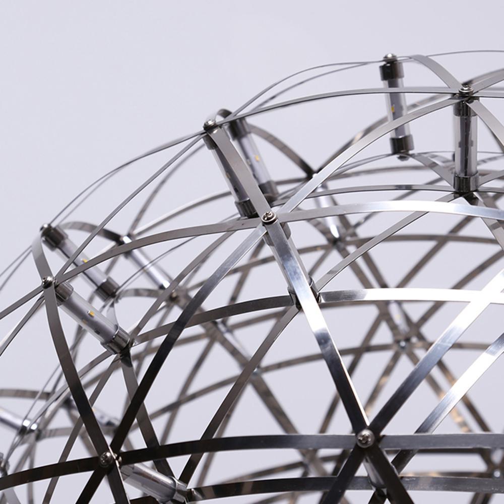 Close-up of clear cylindrical LED nodes, polished metal strips and curved wire hoops