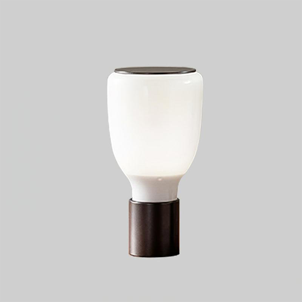 White bottle-shaped glass lamp with rounded upper body, short lower neck, black base and dark top disk