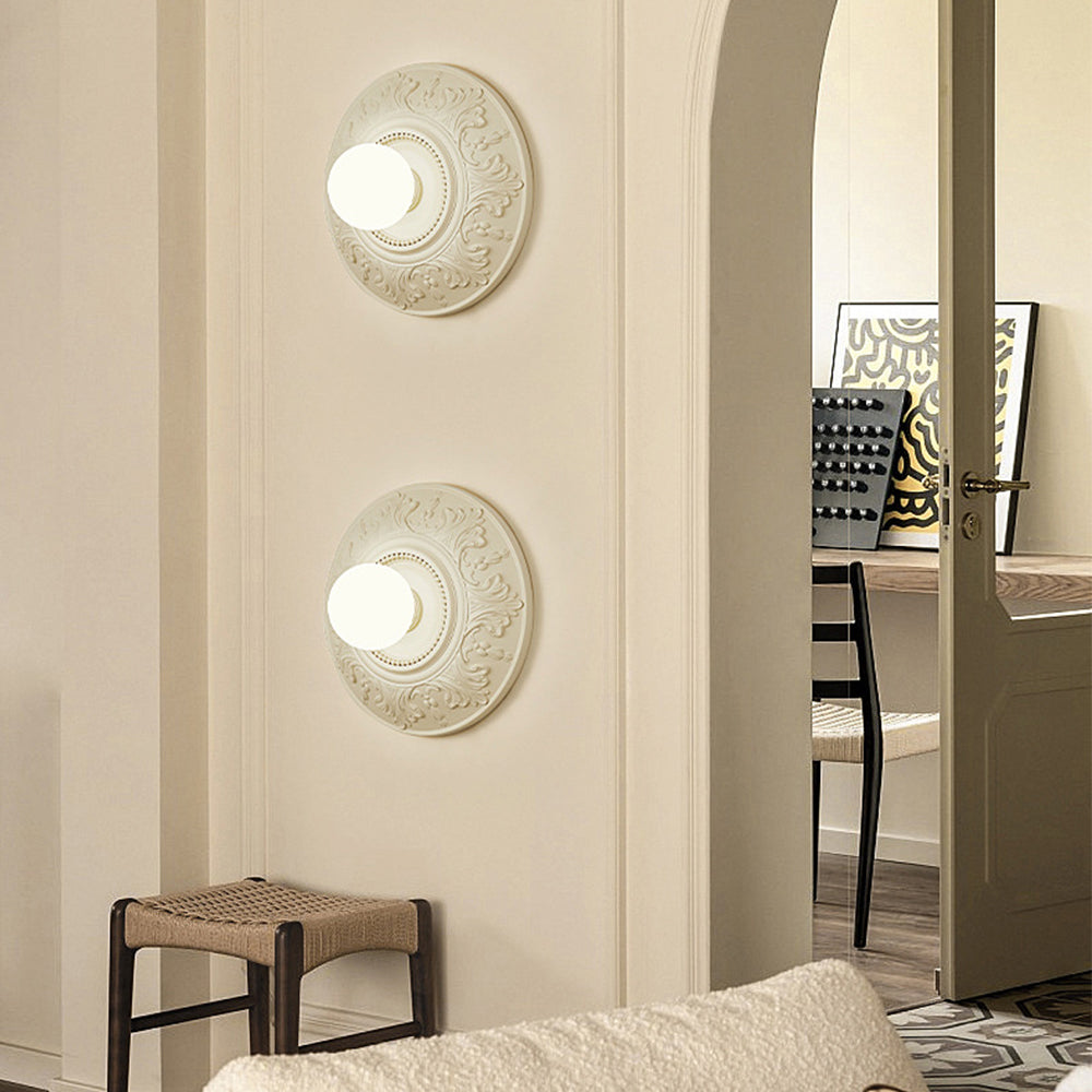 Two cream medallion globe lights arranged vertically beside an arched doorway and woven stool