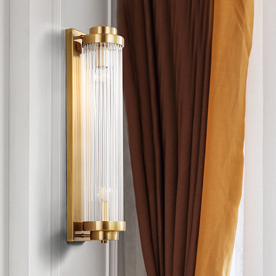 Unlit Gold clear-rod wall light on white panelling beside brown and ochre curtains