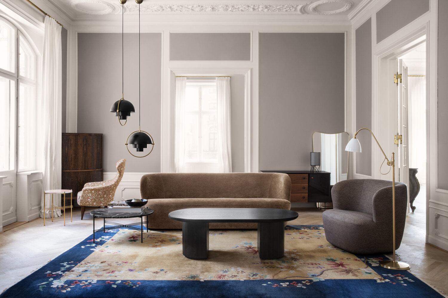 Black ring pendants at the side of a pale living room with a blue rug.