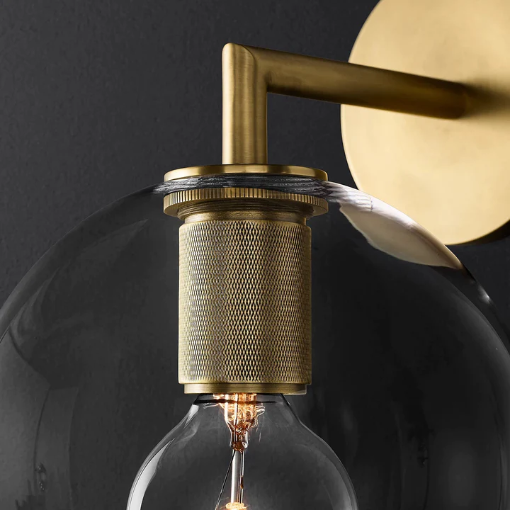 Close globe-shade upper rim and retaining ring around a knurled gold-tone bulb holder