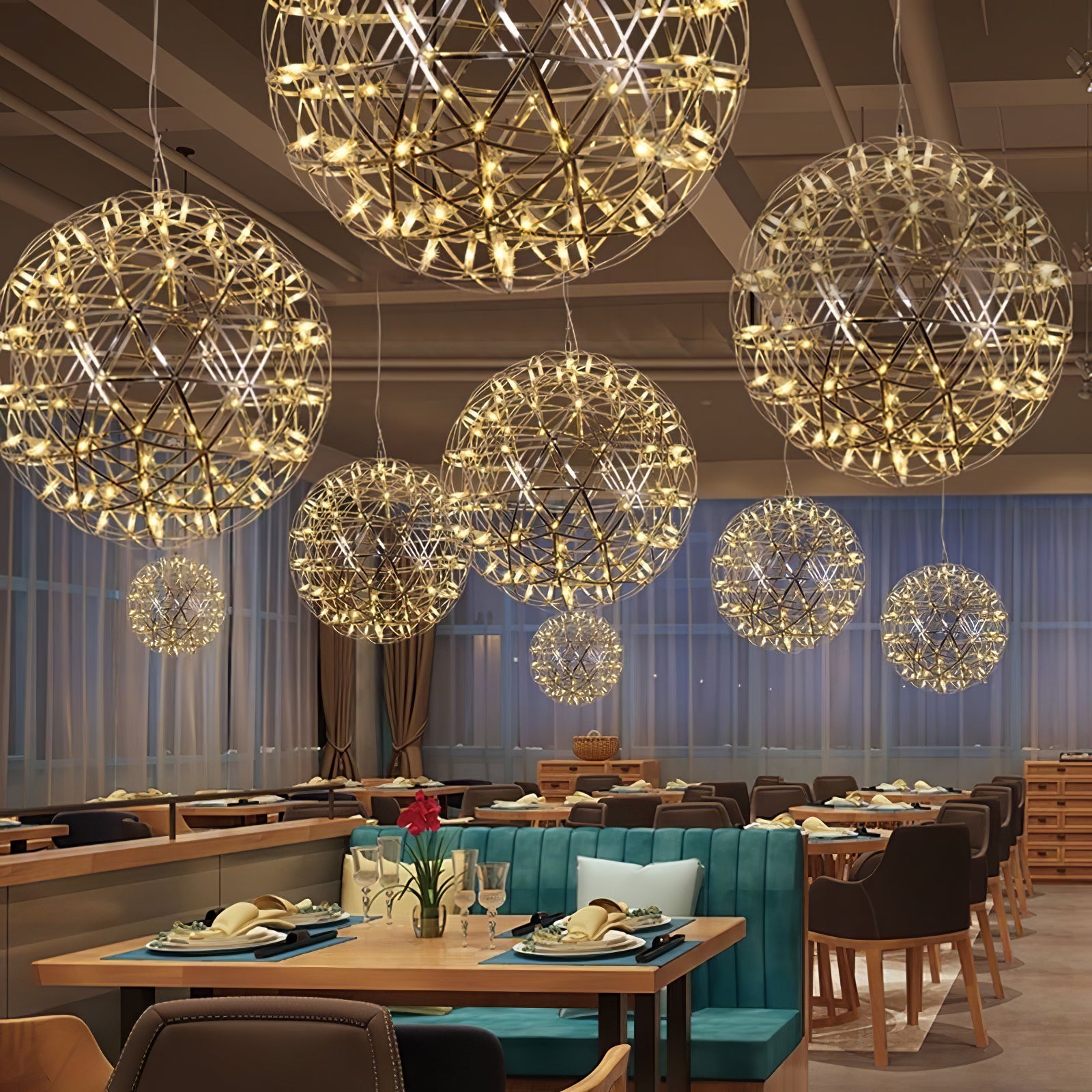 Lit lattice globes above turquoise restaurant booths with orchids and tableware