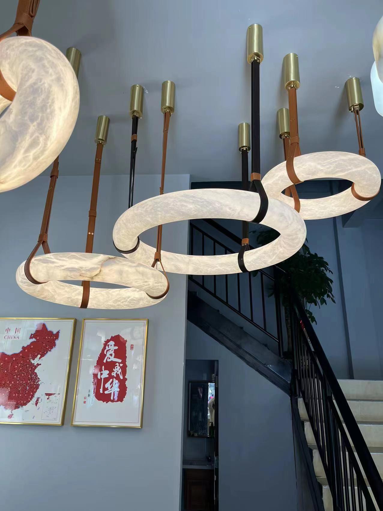 Several illuminated rings on brown straps near an indoor staircase.