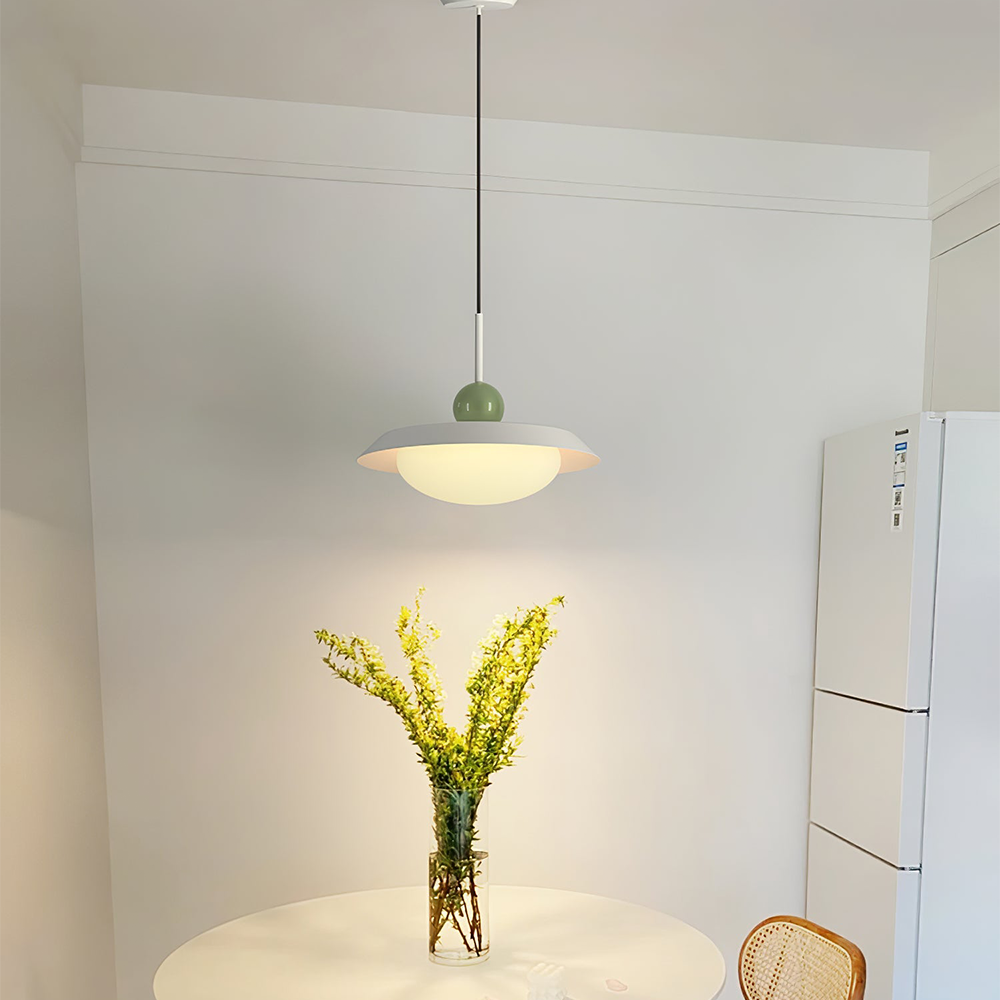 Morandi white single-shade pendant with a green sphere and glowing bowl above a round dining table