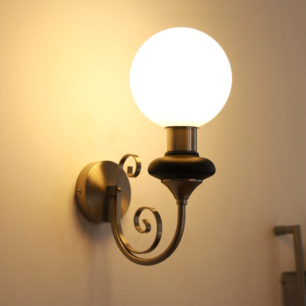 Chrome-and-black globe sconce in a warm-lit room