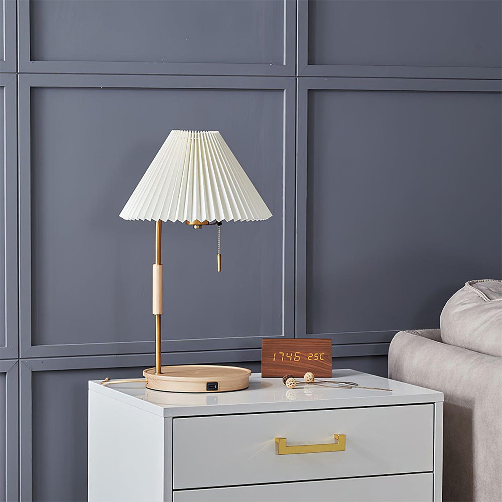 Glowing pleated lamp with a pale wood base and front USB port beside a wooden clock on a white cabinet