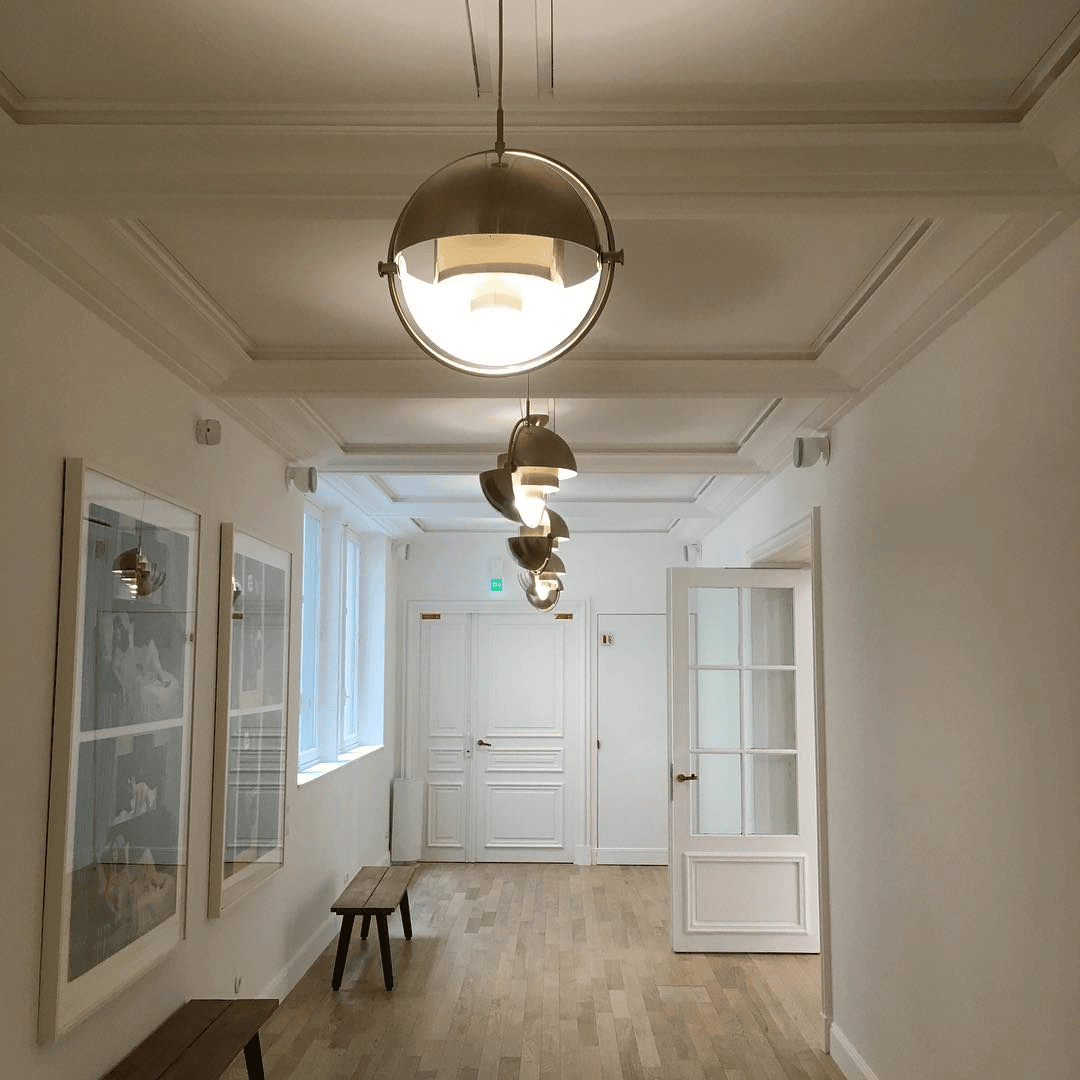 Series of illuminated round pendants along a bright corridor.