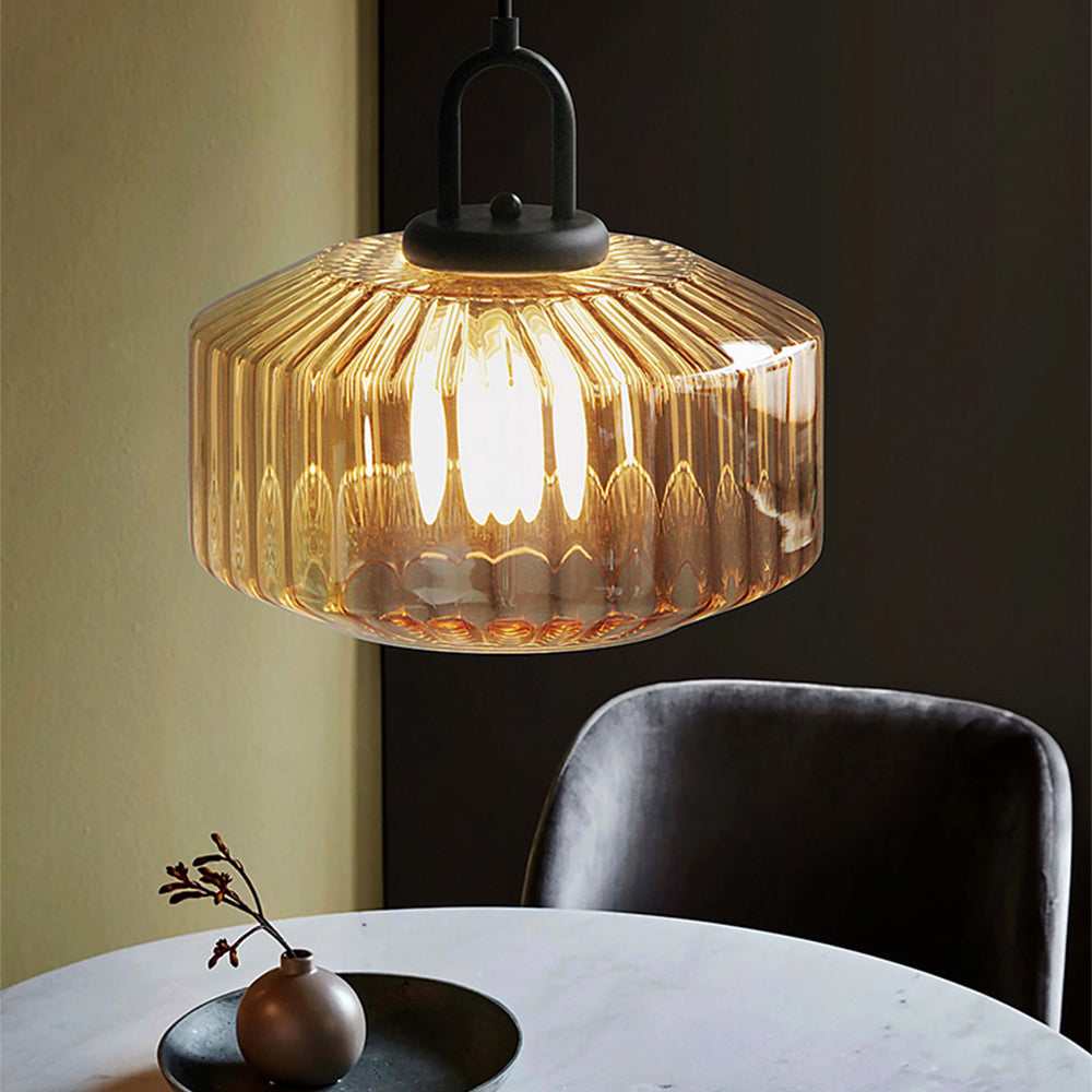 Close view of an illuminated Orange ribbed-glass pendant