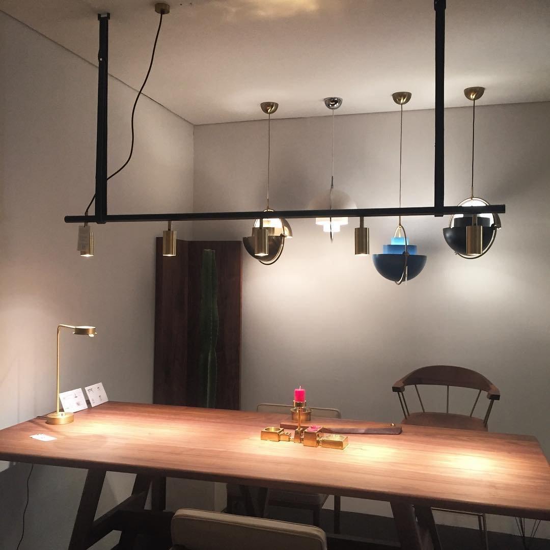 Several ring pendants displayed along a rail above a wooden table.
