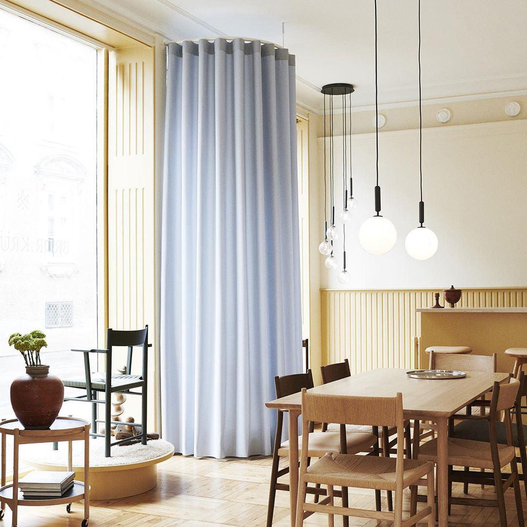 Staggered white globes near tall curtains