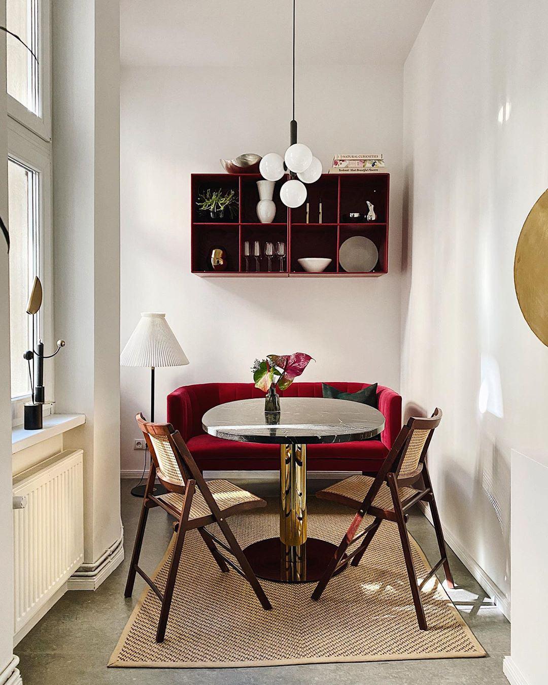 White globe cluster above a red-accent dining nook