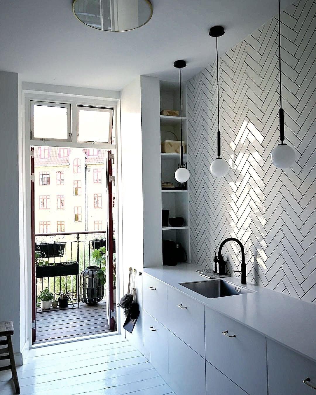 Single white globes above a kitchen sink