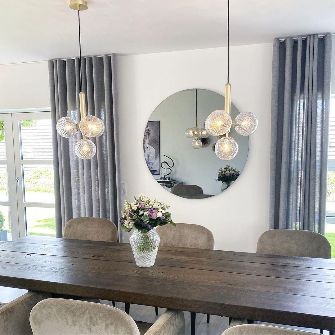 Two clear globe clusters above a dining table
