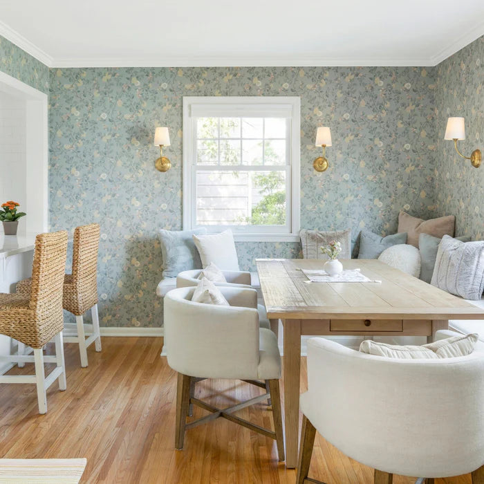 Brass single-shade wall lights across a pale blue dining-room wall.