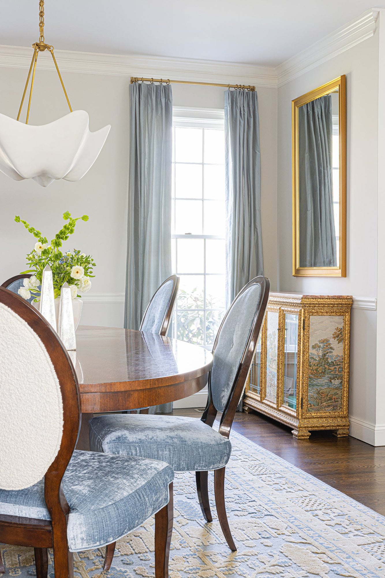 Cosima chandelier and warm metal supports in a dining room