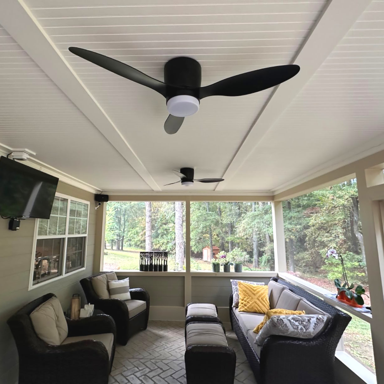 Black fan photographed above covered-porch seating
