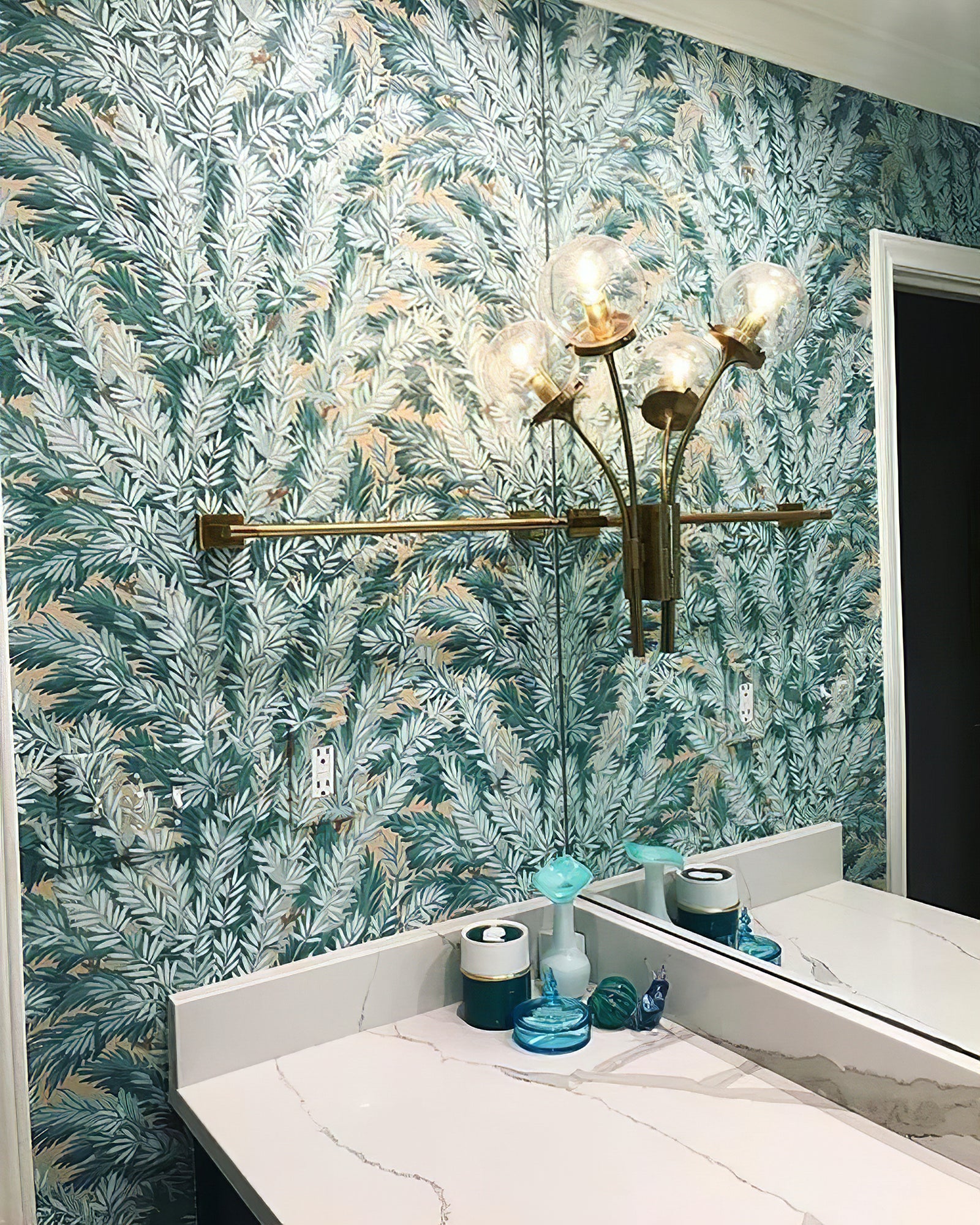 Dark clear-glass sconce beside a bathroom mirror
