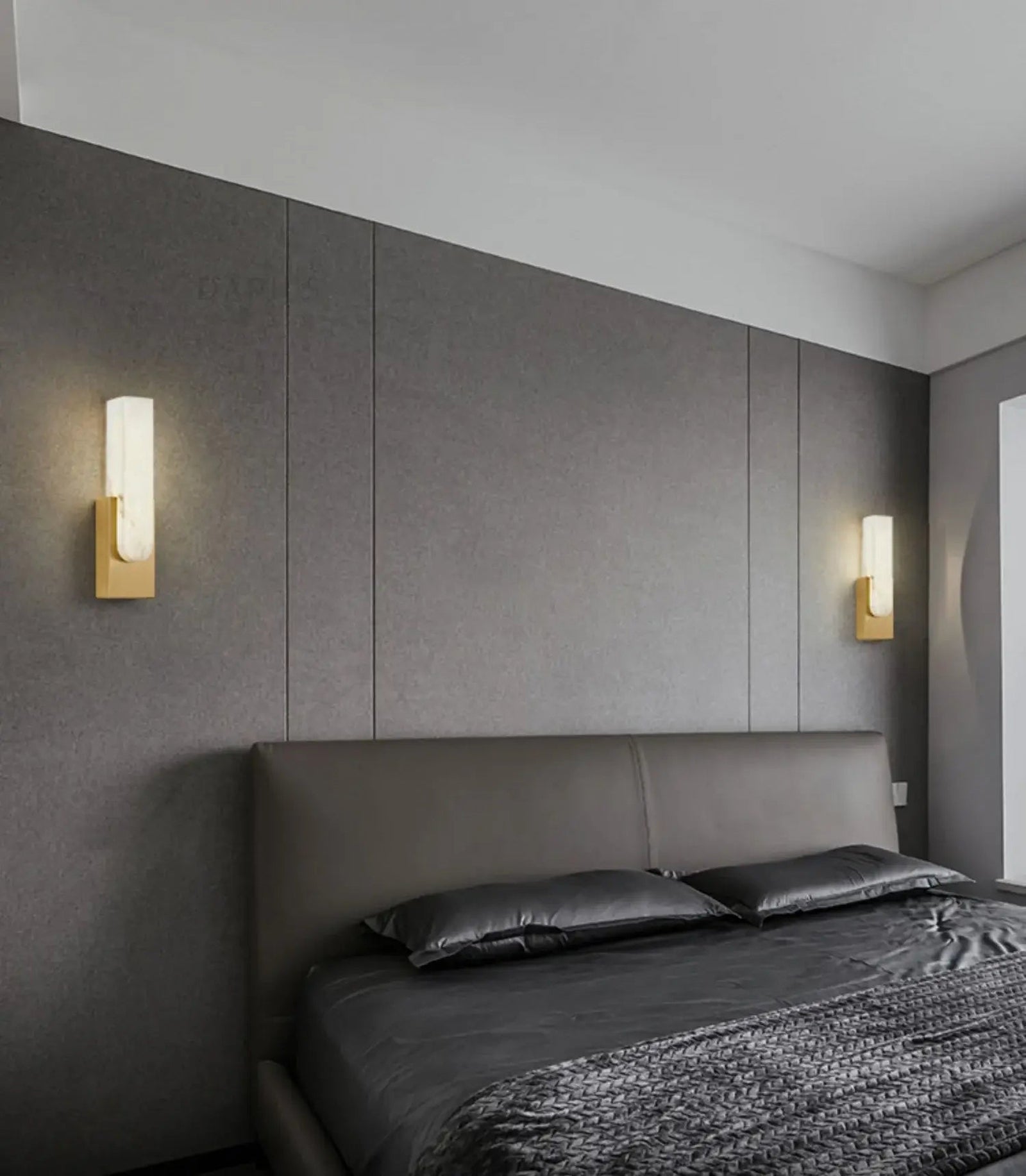Pair of gold wall sconces beside a bed
