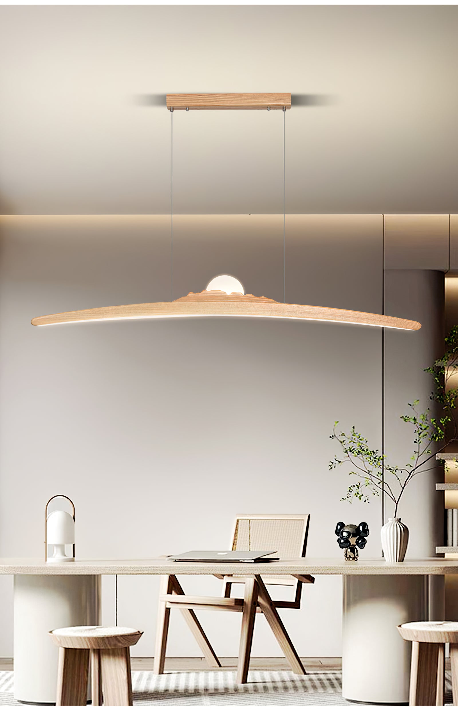 Pale curved bar pendant above a light table with a laptop, lantern, vase and wooden chair