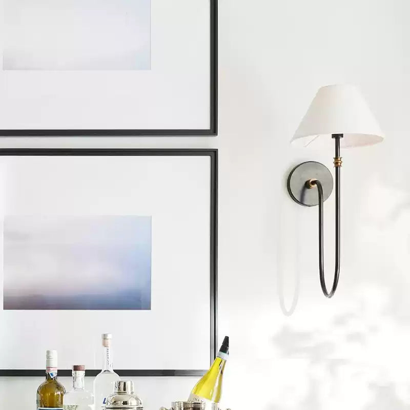 Single Collins black wall lamp beside framed art
