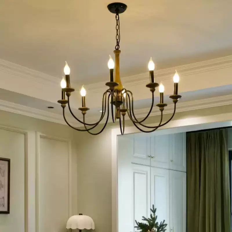 Wood-toned multi-arm chandelier with black chain above a pale room with curtains and decorative tree