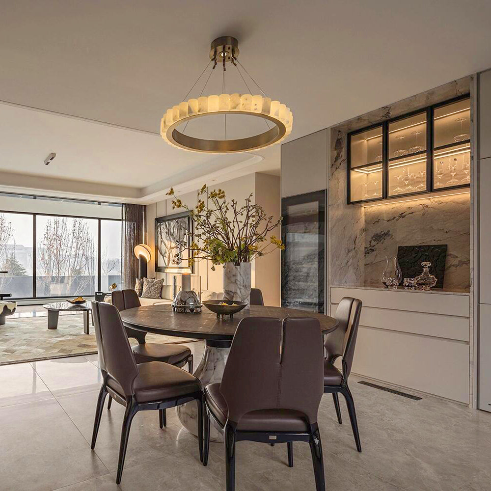 Single pale segmented ring with gold-tone band over a dining table and brown chairs