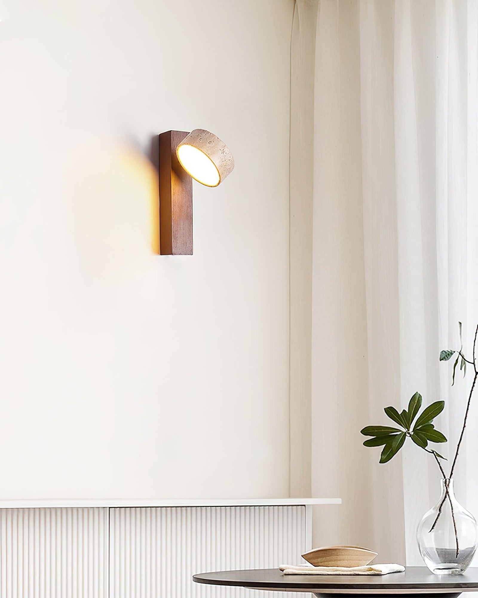 Dark wood-colour stone wall lamp with angled shade beside a window