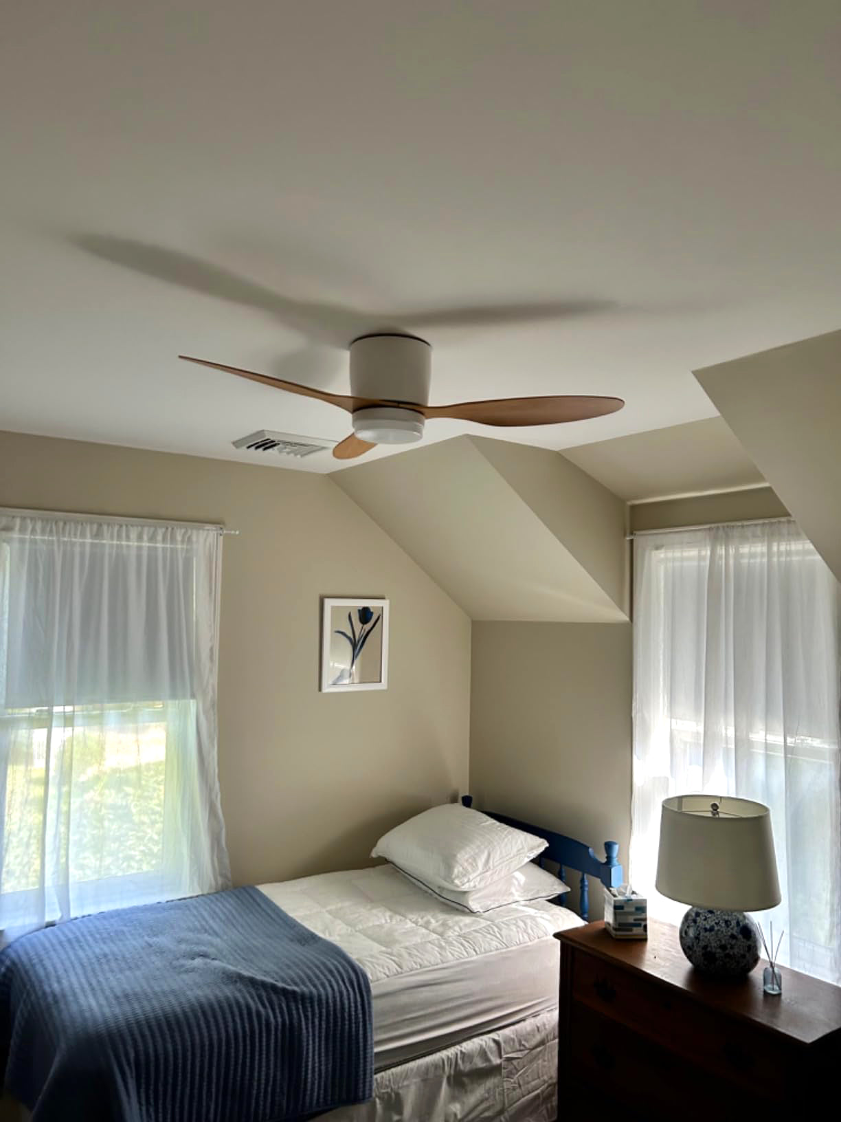 Wood-toned fan above a bedroom