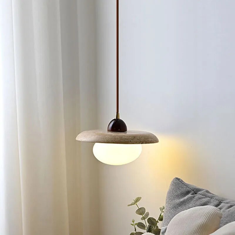Stone pendant suspended near bedroom curtains and cushions