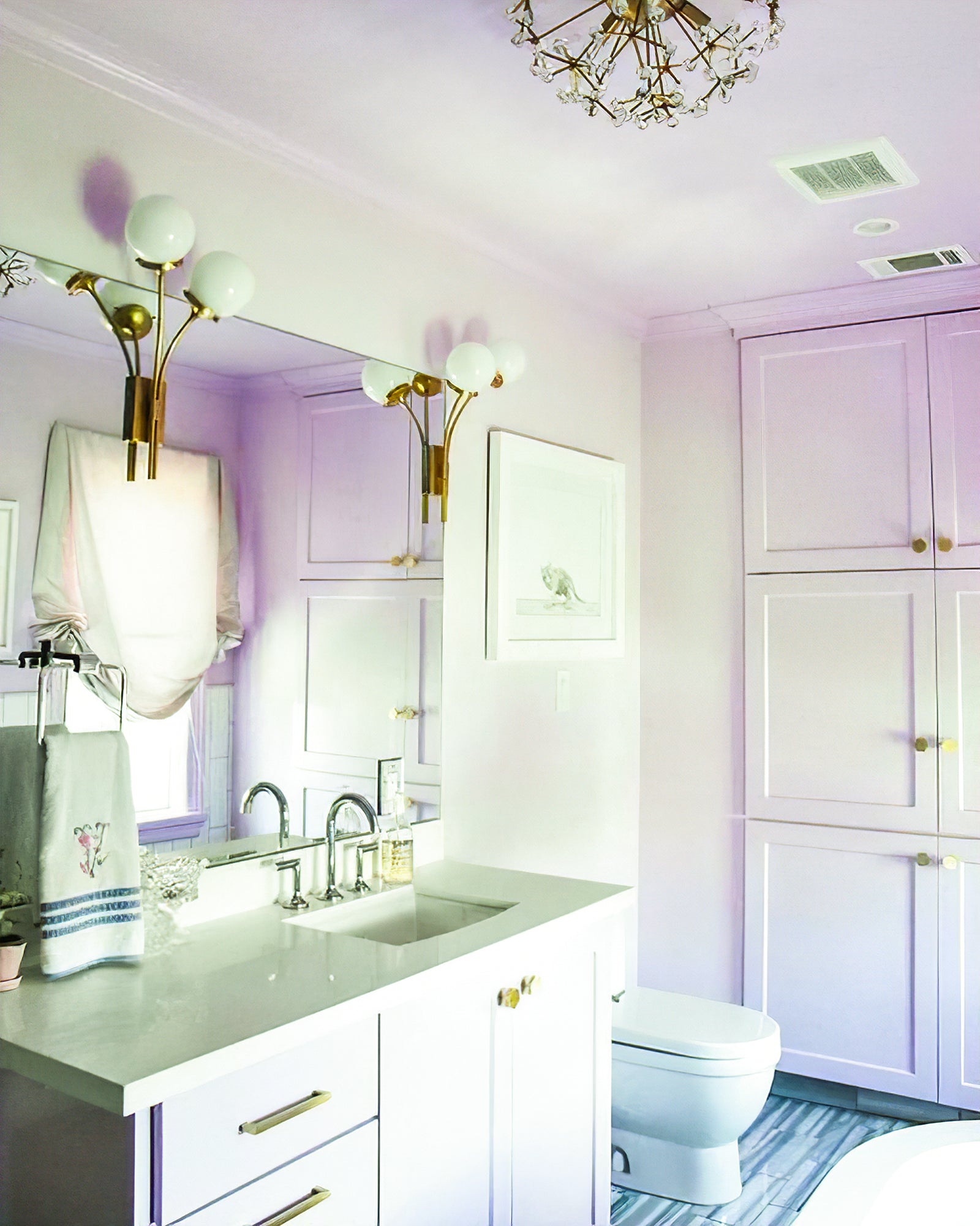 Brass and white-glass sconces at a bathroom mirror