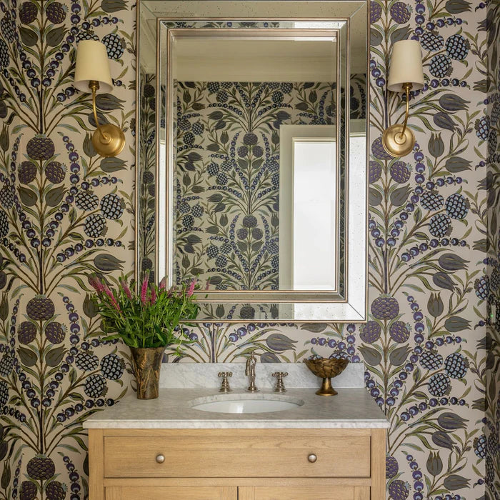 Brass single-arm wall lights flanking a mirror on botanical wallpaper.