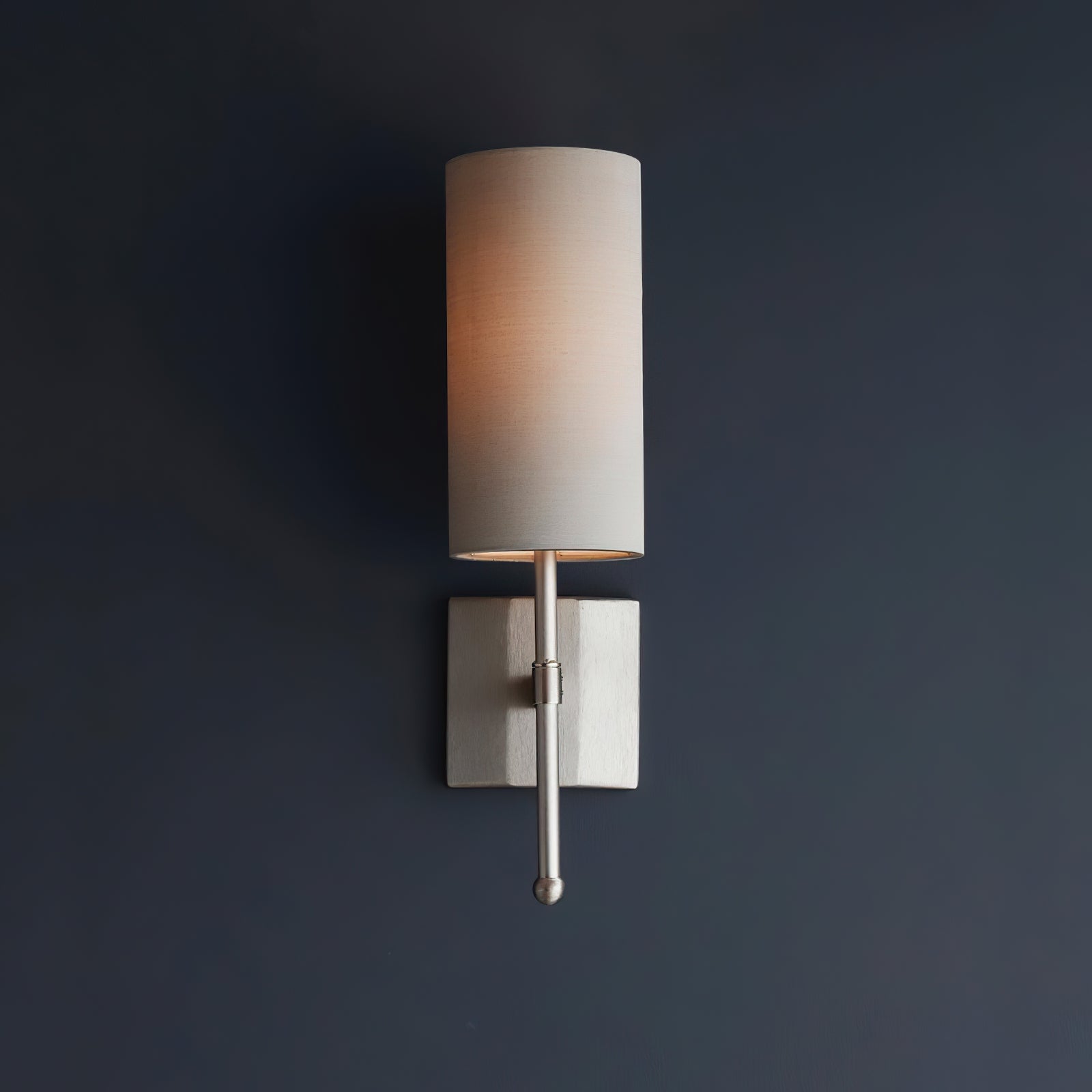 Silk Double Rod single fabric shade illuminated on a dark wall