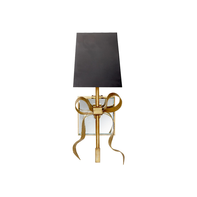 Front view of Antique Brass bow wall light with black tapered shade, curling ribbon tails and reflective backplate
