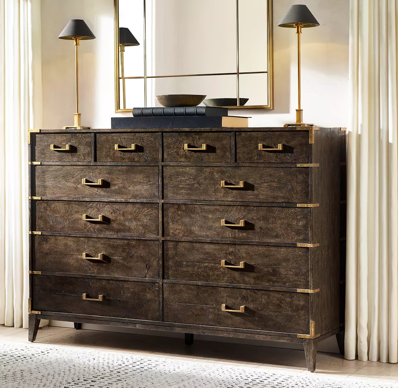 Two Gold B Slim Candlestick lamps with dark conical shades on wooden chest below gold-framed mirror