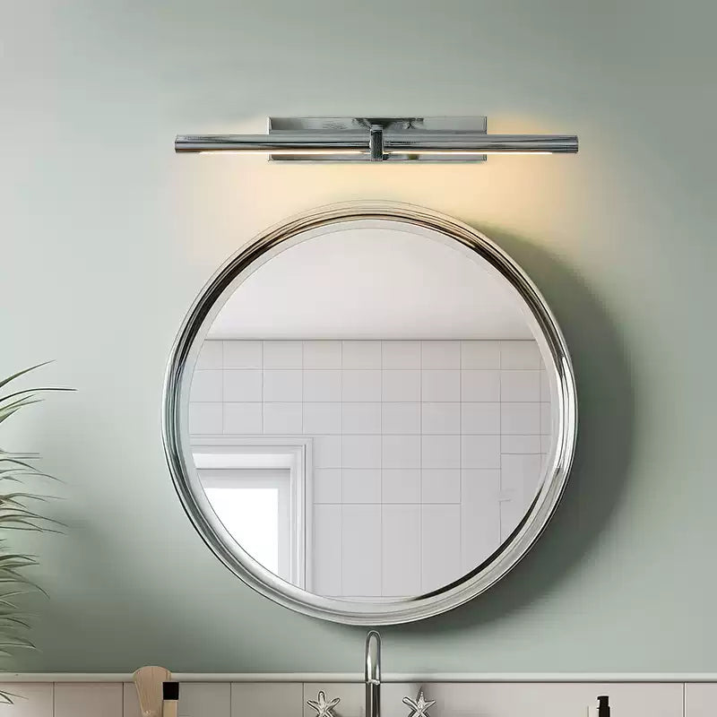 Silver-colour picture light above a round silver-rimmed mirror and basin against pale tiles