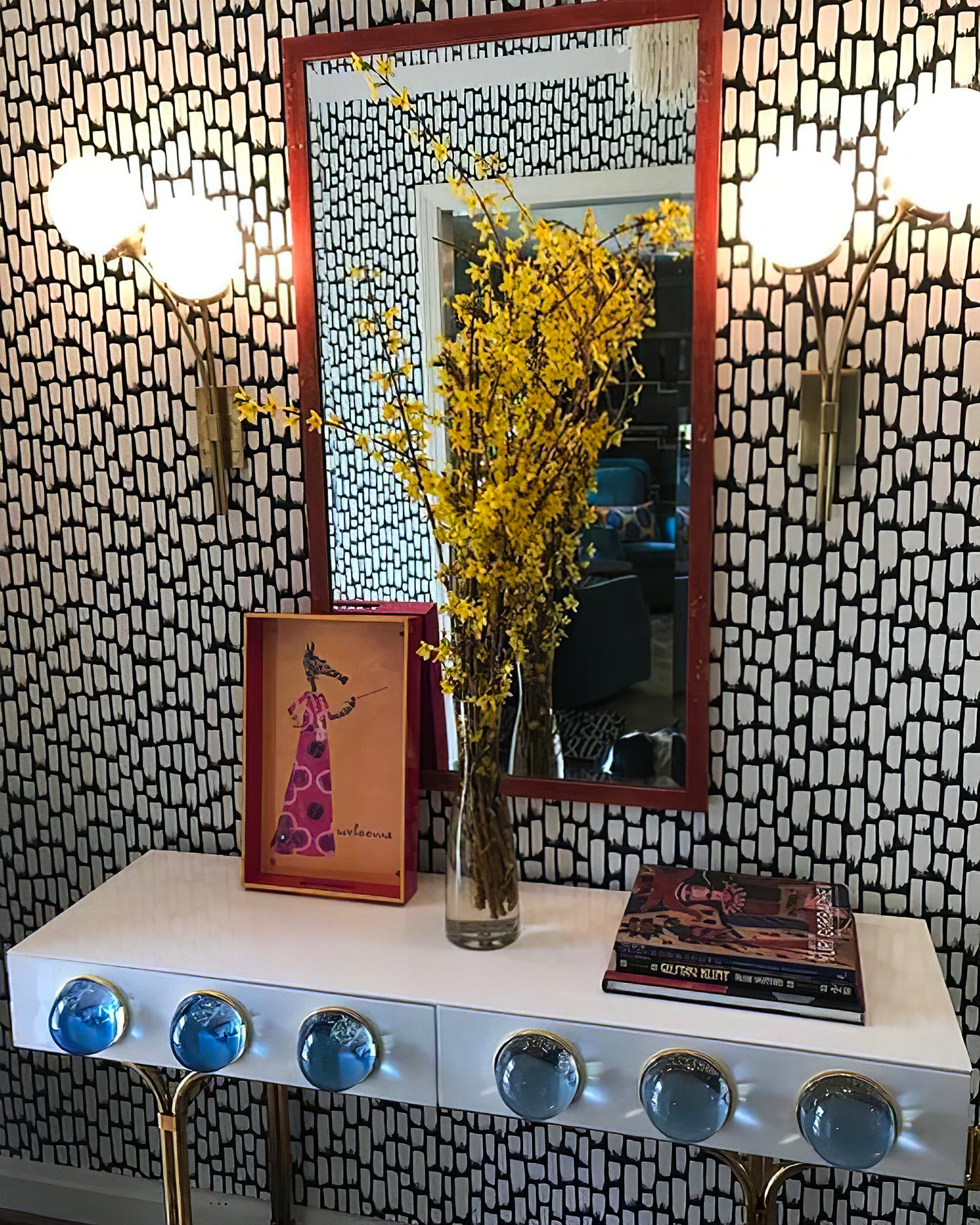 Brass clear-glass sconce above a console