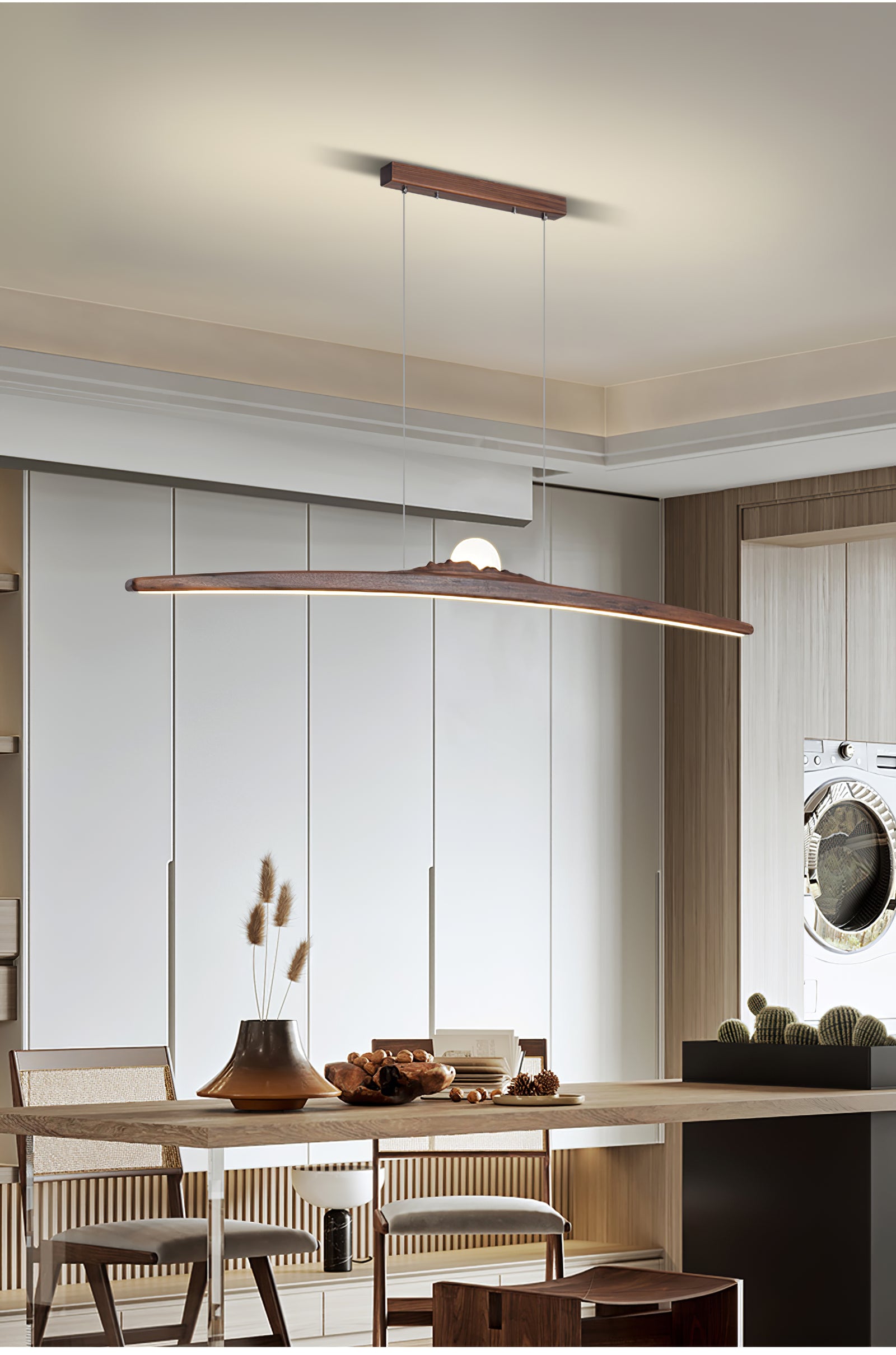 Dark wood pendant above a table with dried stems and woven chairs near cabinets and a cactus