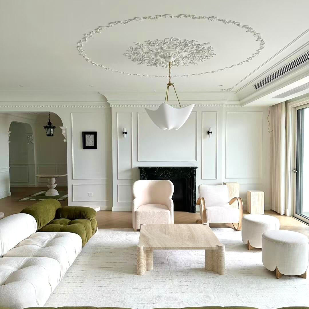 White Cosima chandelier beneath a decorative living-room ceiling