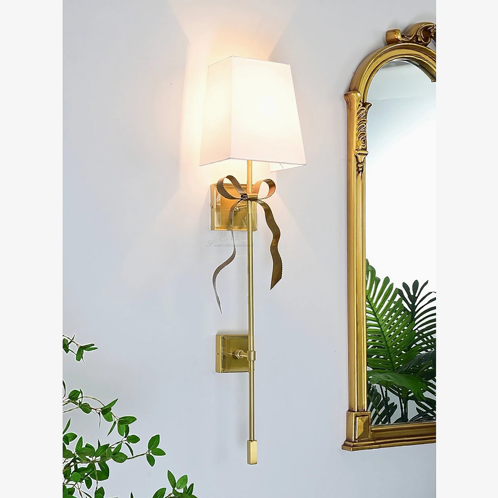 White Ellery sconce beside an ornate gold mirror