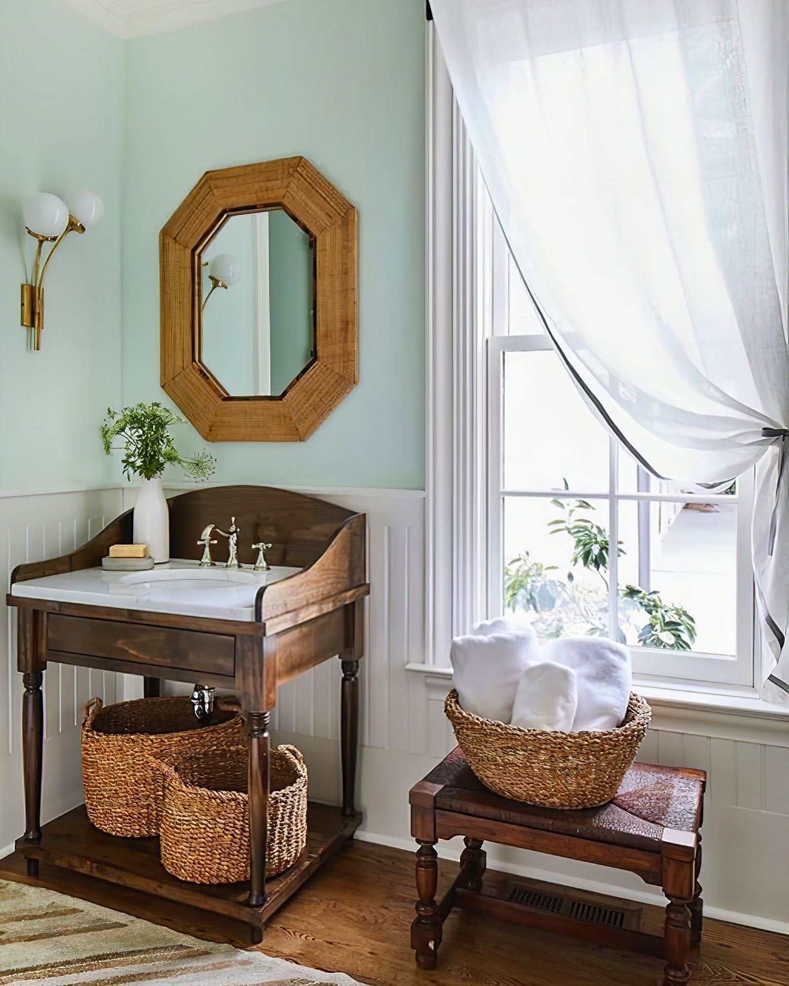 Brass white-glass sconce near a mirror and chair