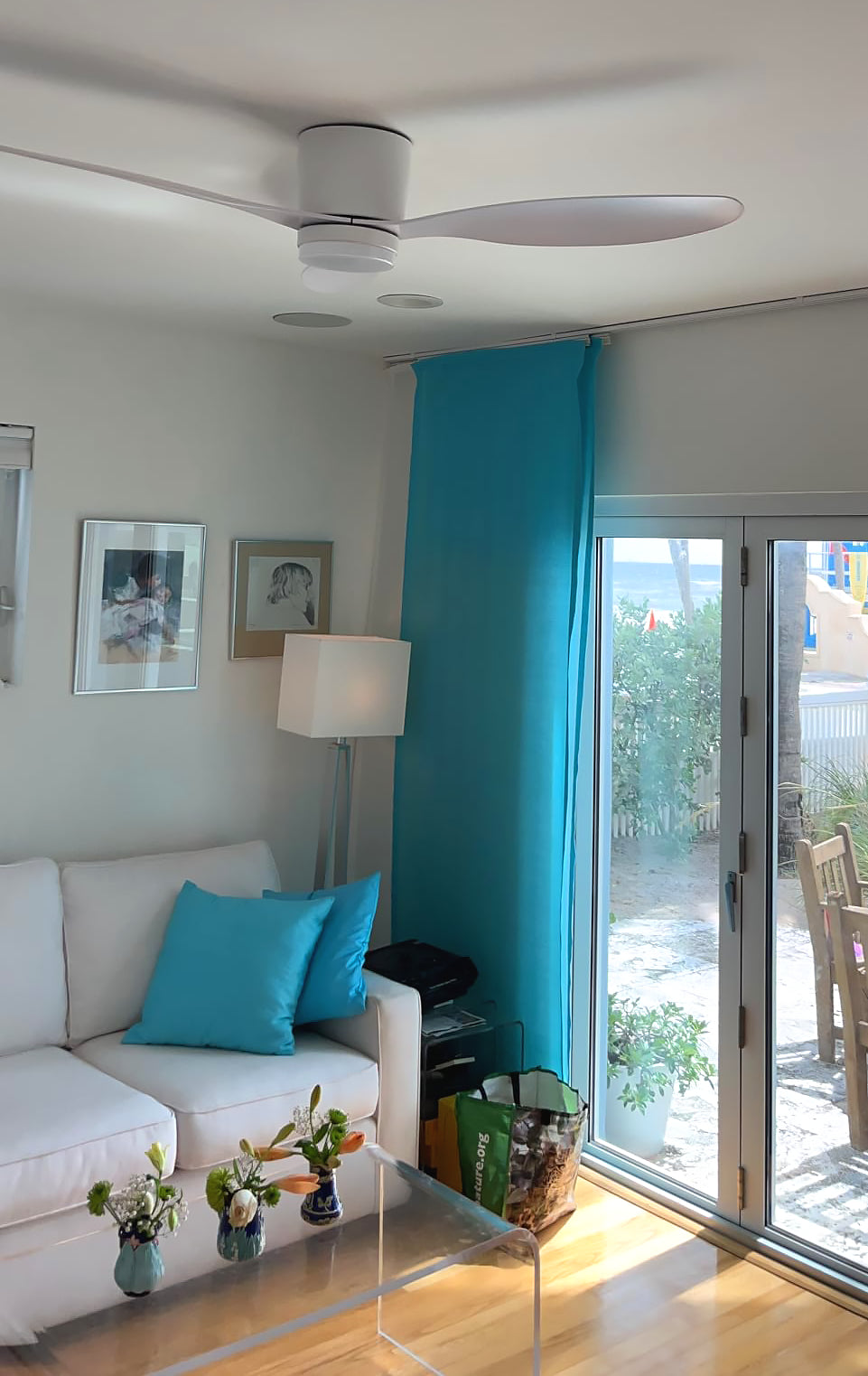 White ceiling fan in a living room beside a window
