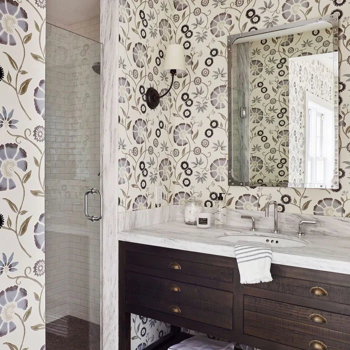 Linen-shade wall lighting around a mirror above a dark bathroom vanity.